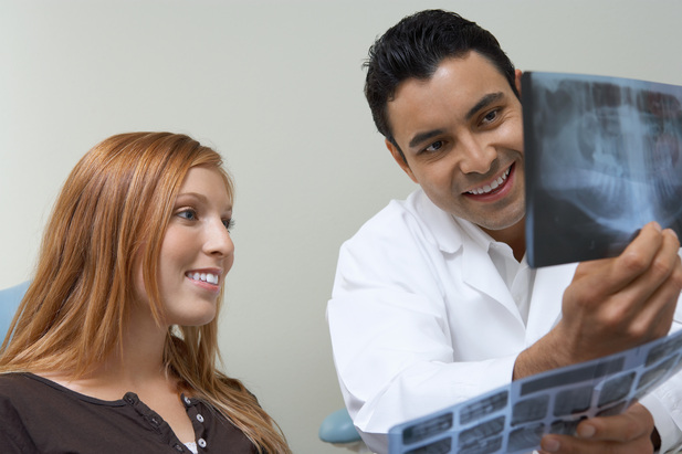 Smiling Dentist with patient x rays photo